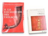 two books on a white table with a red cover and a gold horn