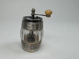 a silver pepper mill with a wooden handle on a white surface