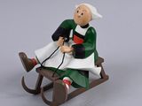 a figurine of a man sitting on a sled
