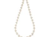 un collier de perles blanches avec un fermoir en or sur fond blanc