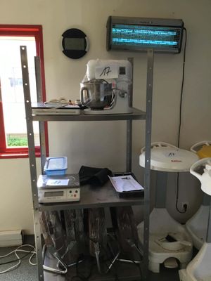 a small kitchen with a metal shelf and a tv