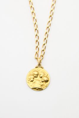 un collier en or avec une pièce de monnaie sur une chaîne
