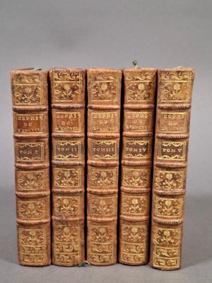 six vieux livres sont empilés sur une table