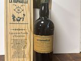 une caisse en bois posée sur une table, avec une bouteille de vin à côté