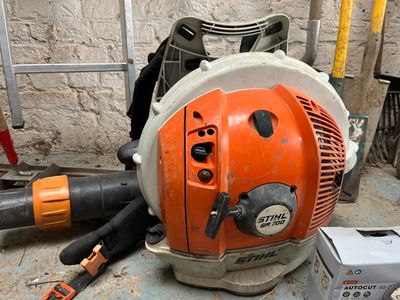 a chainsaw that is sitting on the floor next to other tools