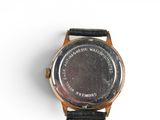 wrist watch on a white surface with a black leather strap