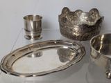 a silver plate with a bowl and a silver cup on a table