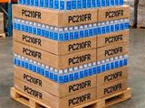 Des cartons d'eau sont empilés sur une palette dans un entrepôt