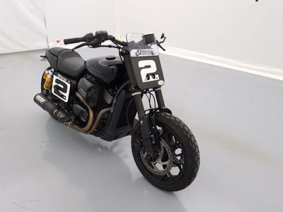 une moto noire garée dans une pièce aux murs blancs