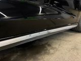 a black car parked in a garage with its door open