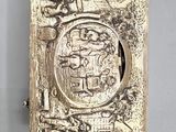 an antique silver cigarette case with a picture of a man and a woman on it
