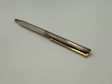 a close up of a pen on a table with a white background