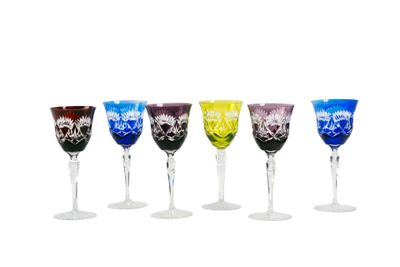 six verres à vin de couleurs différentes posés les uns à côté des autres sur une surface blanche