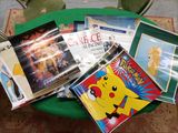 de nombreux livres posés sur une table verte, avec une chaise verte en arrière-plan