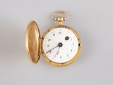 a gold pocket watch sitting on a white surface
