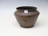 a brown vase sitting on a white surface