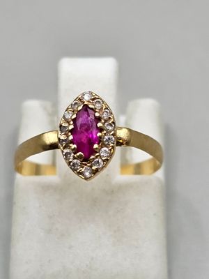 a yellow gold ring with a ruby stone and diamonds
