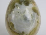 an image of a green and white marble egg on a gold stand