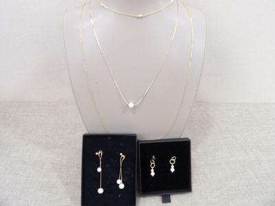 ensemble composé d'un collier et de boucles d'oreilles présenté dans un coffret noir sur fond blanc