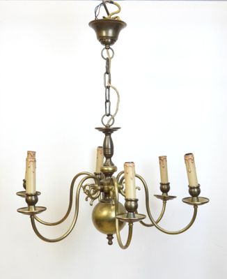 une image représentant un lustre auquel sont suspendues cinq bougies, fixé au plafond