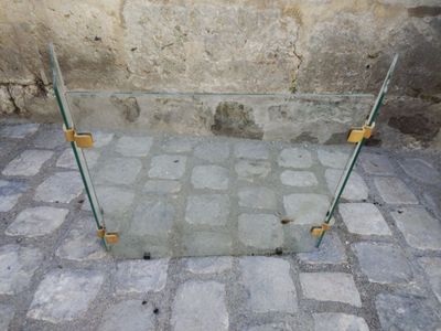 une table en verre posée sur un sol en pavés
