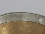 a metal bowl that has a handle on it