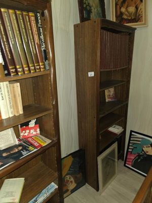 une bibliothèque avec des livres posés dessus, dans un coin de la pièce