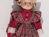 a doll that is wearing a red hat and dress