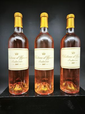 trois bouteilles de vin sont posées sur une table noire