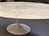 a white marble table with a white pedestal on the floor