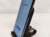 a close up of a cell phone on a stand on a bed