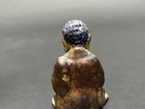two small figurines of people sitting on top of a table