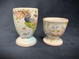 two egg cups that have been painted with words on them