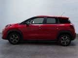 a red citrole parked in a room with a white wall