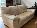 un canapé blanc placé dans un salon, près d'une fenêtre