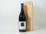 the bottle of red wine is next to a wooden box