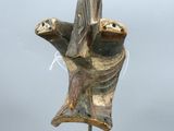 statue représentant une personne tenant un oiseau, posée sur un socle en métal