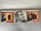 three cd ' s of a man in a suit and a woman in a dress