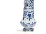 un vase bleu et blanc posé sur une surface blanche