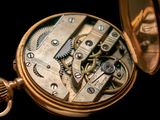 a close up of a pocket watch on a black background