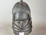 statue d'un homme portant un casque orné d'un oiseau sur la tête