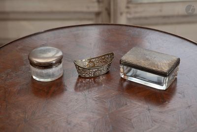 deux objets en argent posés sur une table en bois près d'une fenêtre