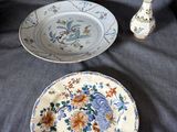 deux assiettes et un vase posés sur un canapé