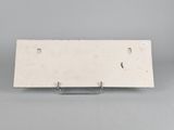 a white sign on a metal stand on a gray surface