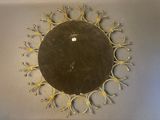 a gold clock on the wall in the shape of a sunburst