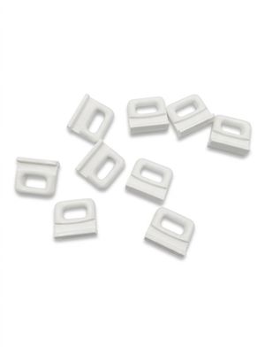 a pile of white plastic clips on a white surface
