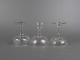 three wine glasses sitting next to each other on a table