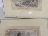 two framed pictures of a castle on display in a glass case