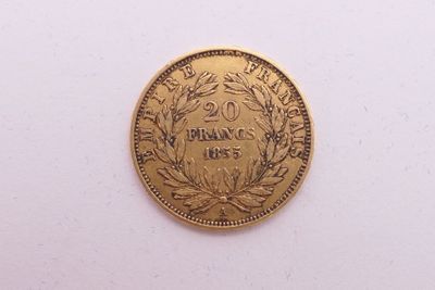 gros plan d'une pièce d'or sur une surface blanche