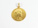 gros plan d'une pièce d'or sur laquelle figure le visage d'un homme